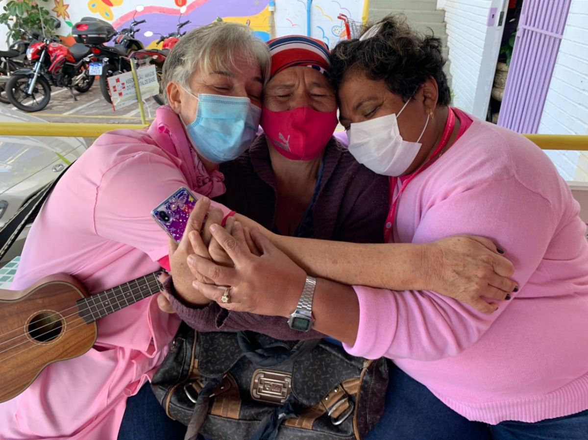 Voluntárias tocando ukulele em roda de abraço